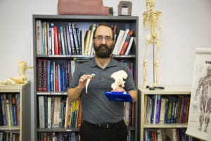Samuel Payzant holds the model of a hip replacement. Physical Therapist Assistants help patients recover mobility following surgery, injury or other impairment.