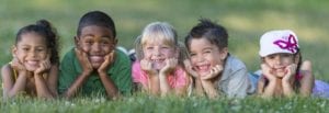 Children smiling as they lay in the grass