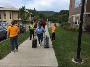 Dr. Ross wheels suitcases into the Student Village