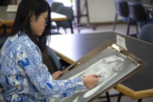 Xiaoying Chen works on a drawing.