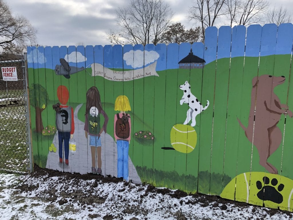 A panel showing the three participating schools who painted the mural at the Broome County Dog Shelter.