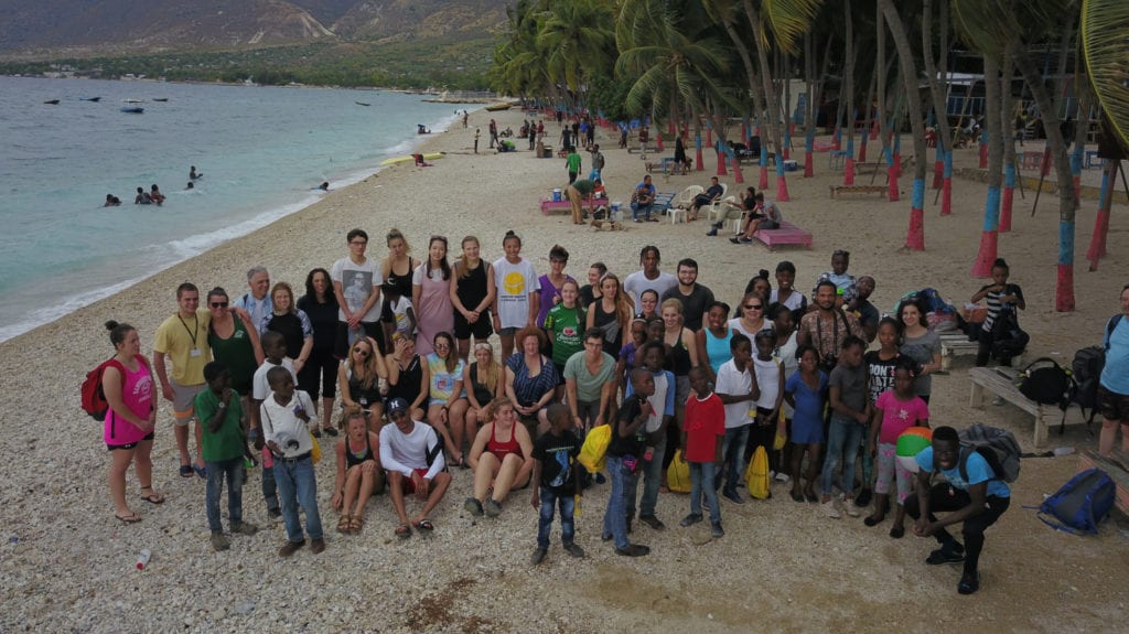Health for Haiti students, professors and staff with Haitian children during the 2019 trip's beach day.