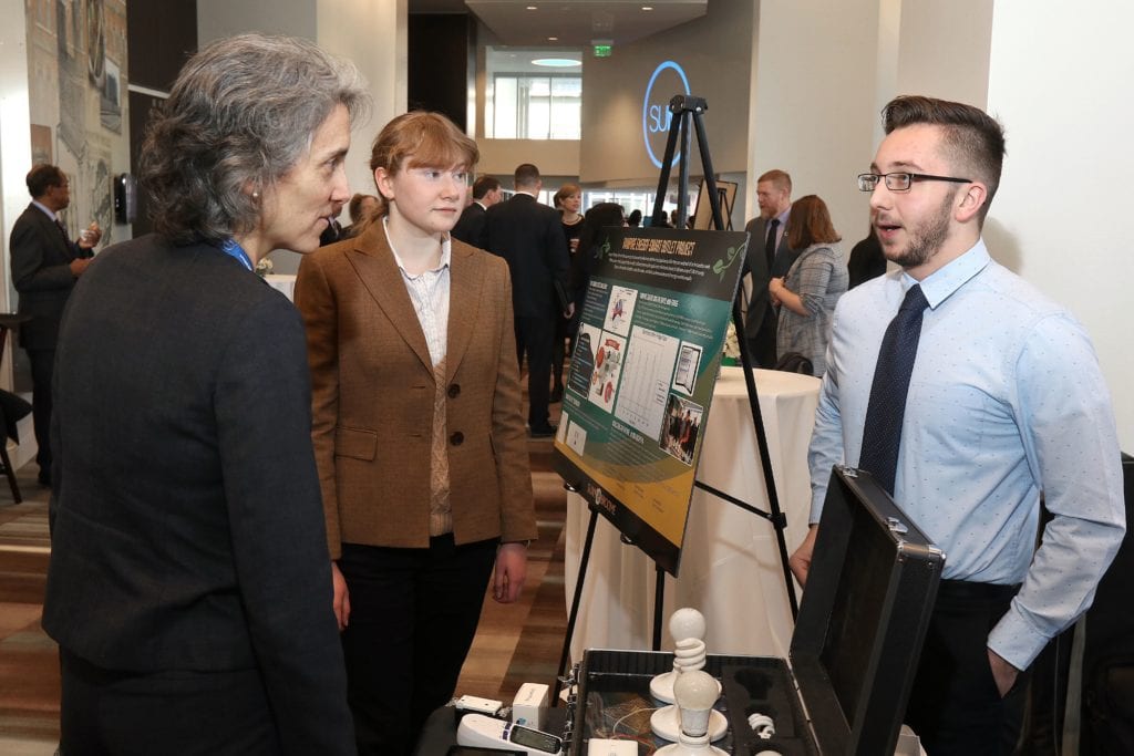 Brandon Kipp (right) and Diana Kelly (center) present their work on energy conservation at the Chancellor's showcase.
