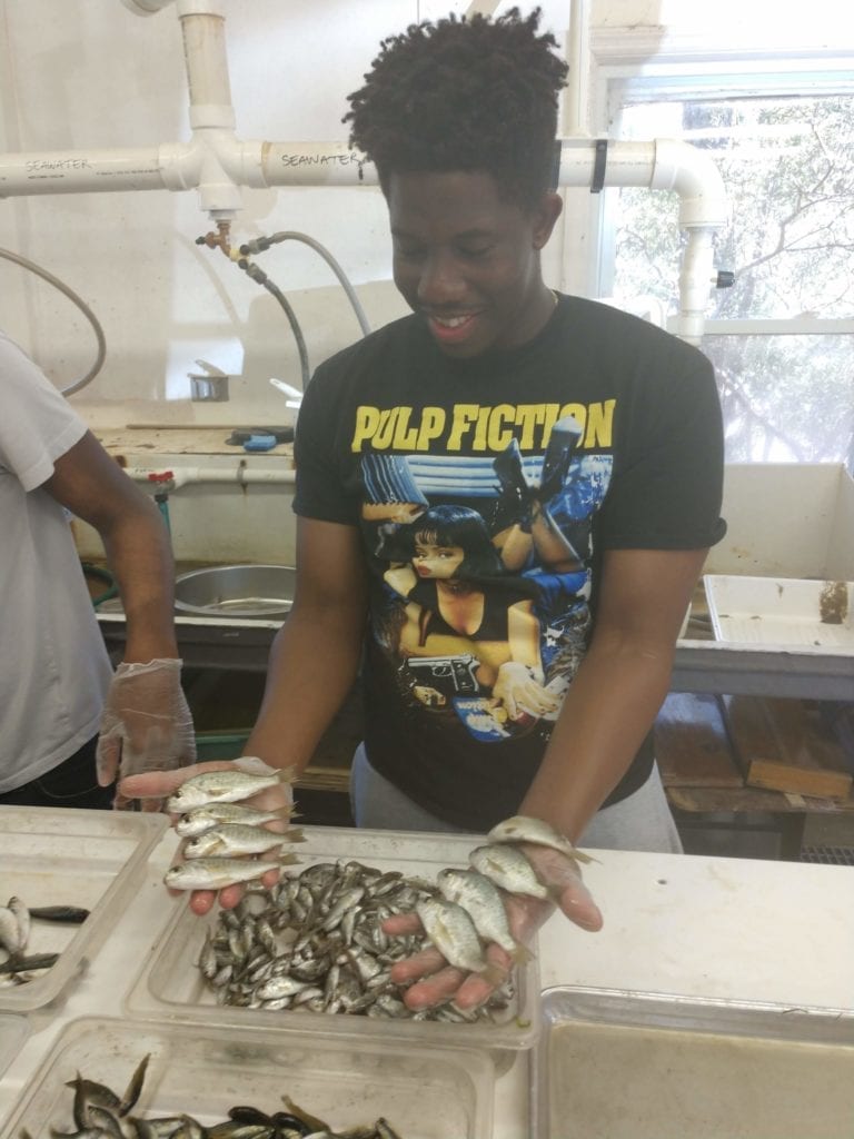 Eli, a SUNY Broome Oceanography student, with fish in South Carolina.