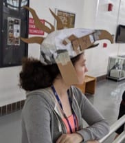 A student in a fantastic hat at the Summer STEAM Academy