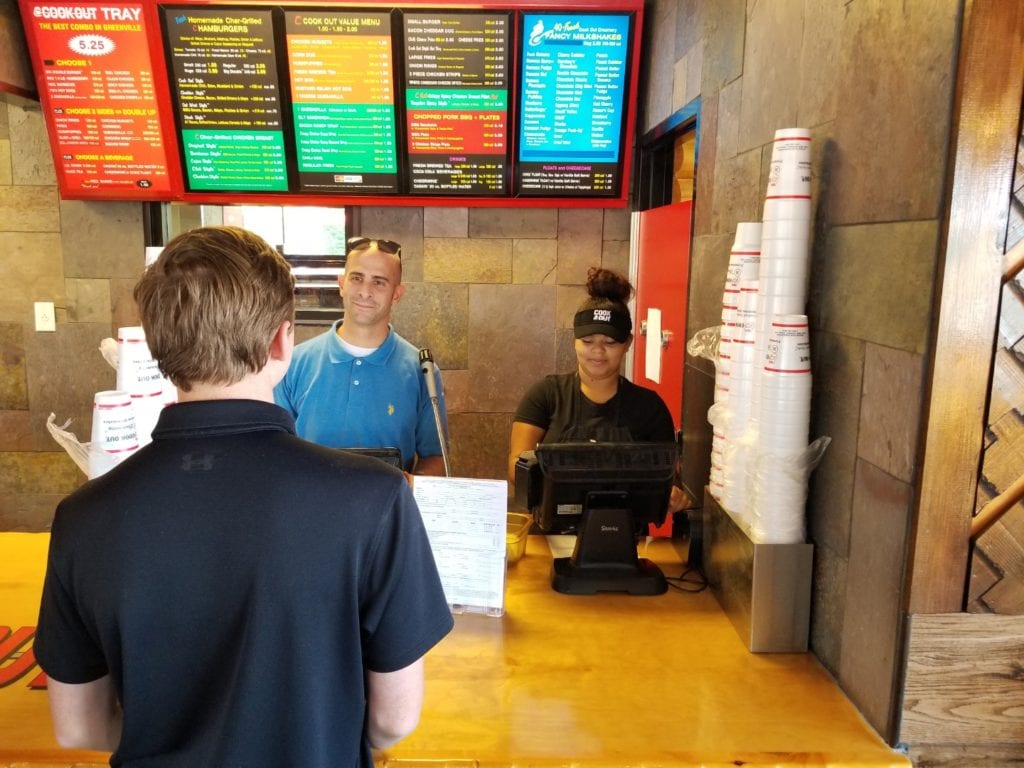 Mike Santacrose, center, with an employee and a customer of CookOut restaurants