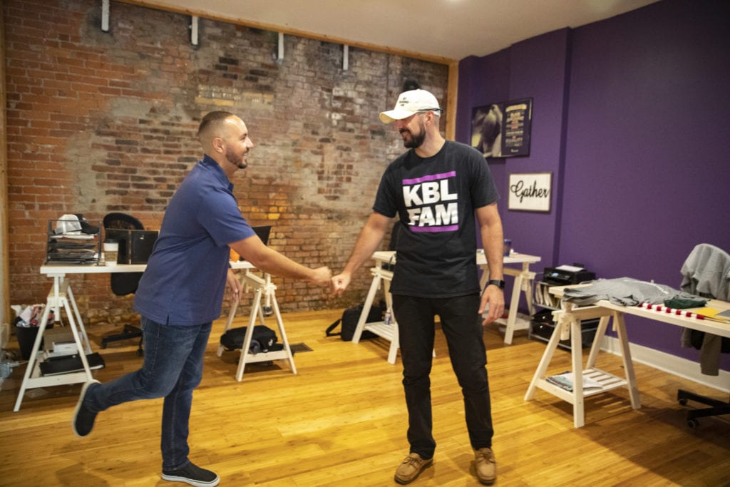 brothers Dave and Adam Sabol do a fist-bump in the offices of Key Branding Labs