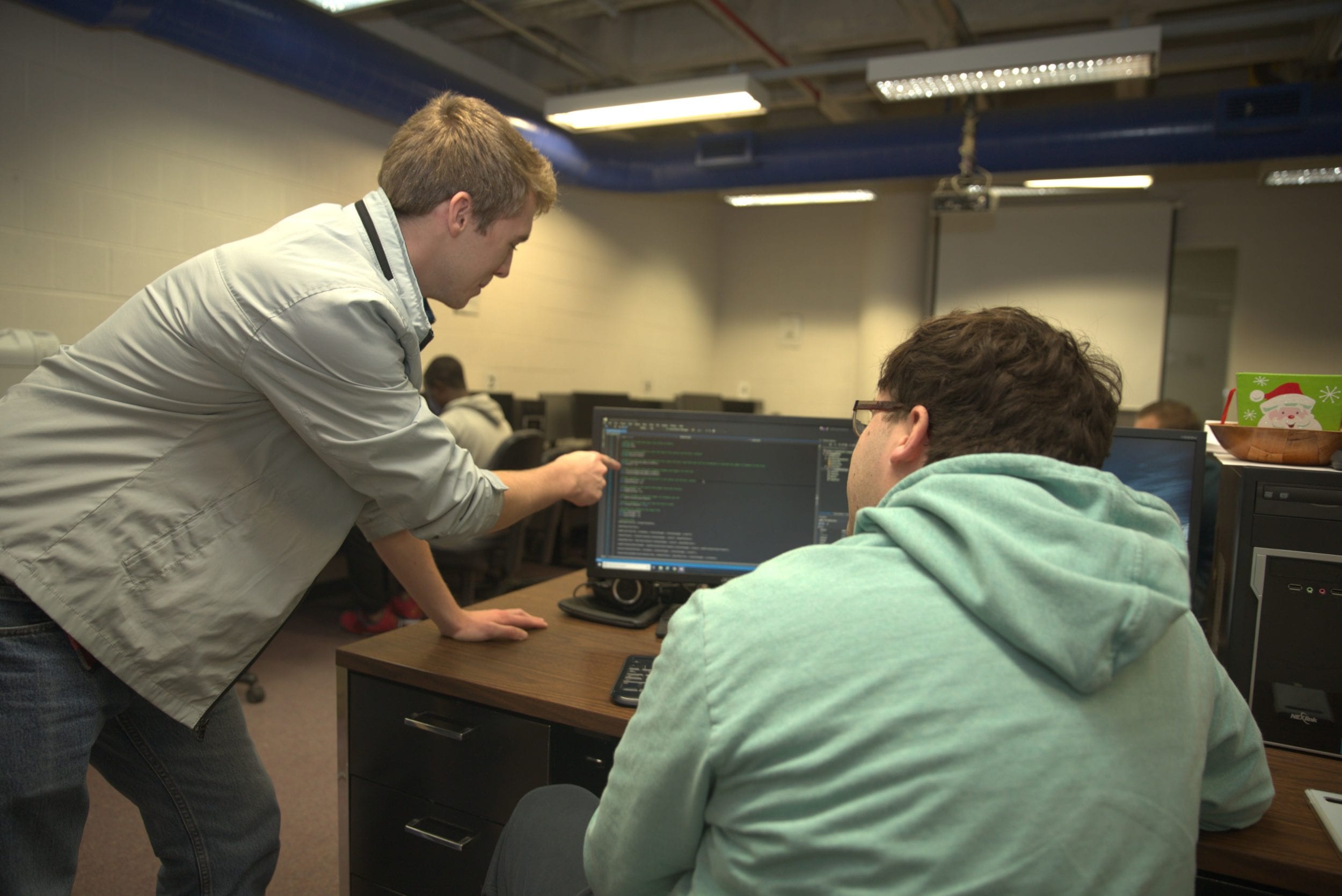Christopher Painter works with a peer in the Computer Lab