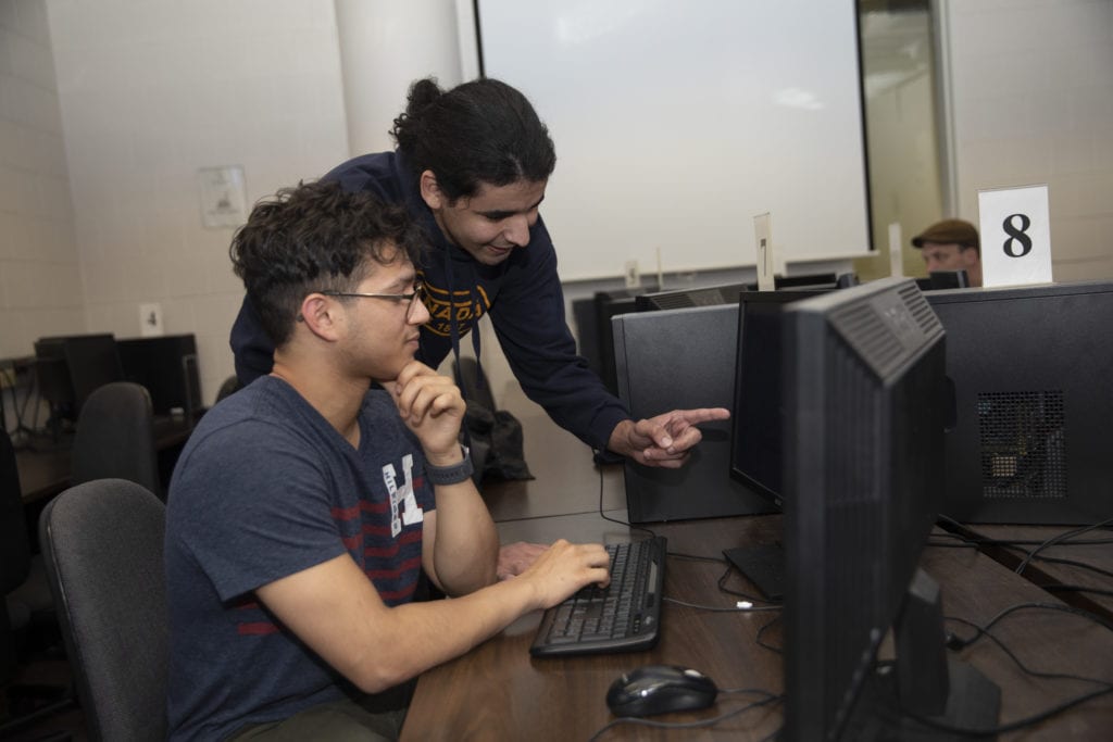 Mohamed Ali Larbi Daho Bachir helps a fellow student in the Computer Science lab