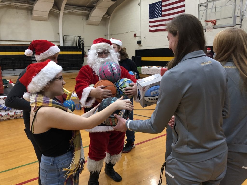 The women's basketball team loads down Santa with the tools of the trade during the Dec. 5, 2019, Giving of the Toys.