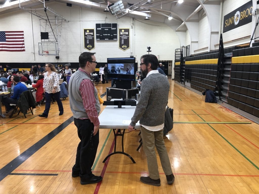 A display shows how classrooms in Oneonta and Binghamton are connected through videoconferencing.