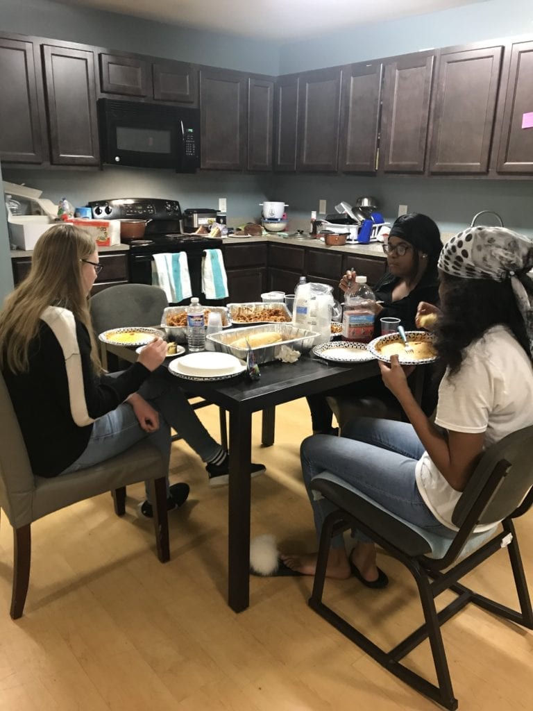 students sitting at table eating dinner