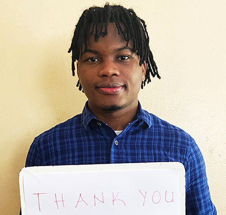 Tatsenyo holds a sign that reads "Thank you, SUNY Broome!".