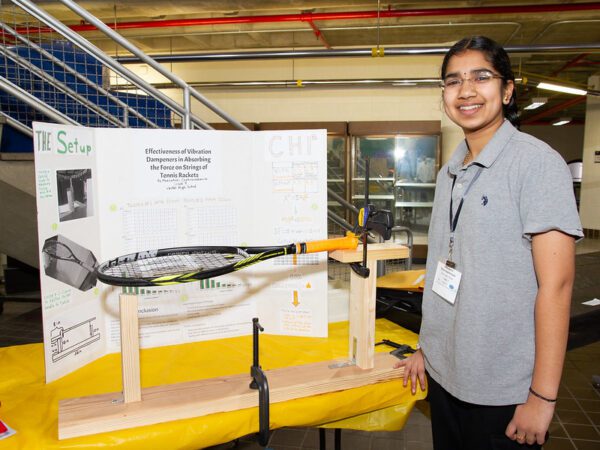 High schooler Meenakshi Chakravadhanula stands with her project.