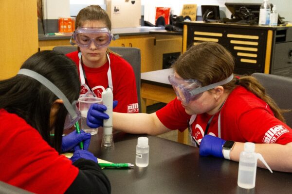 Three students participate in a lab experiment.