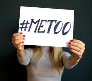 A woman holding a sign that says #MeToo