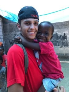 A SUNY Broome student holds a Haitian boy