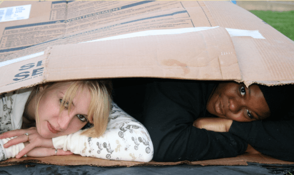 Homeless Awareness: two students sleeping in a cardboard box