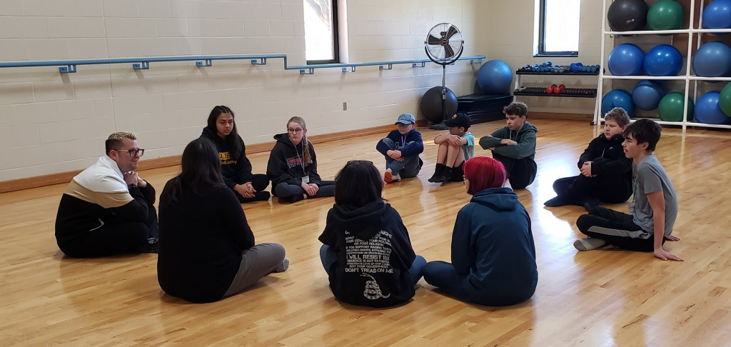 Jesse Katen (far left), owner of the Jesse Katen School of Dance, listening to students prior to leading a sample dance session.