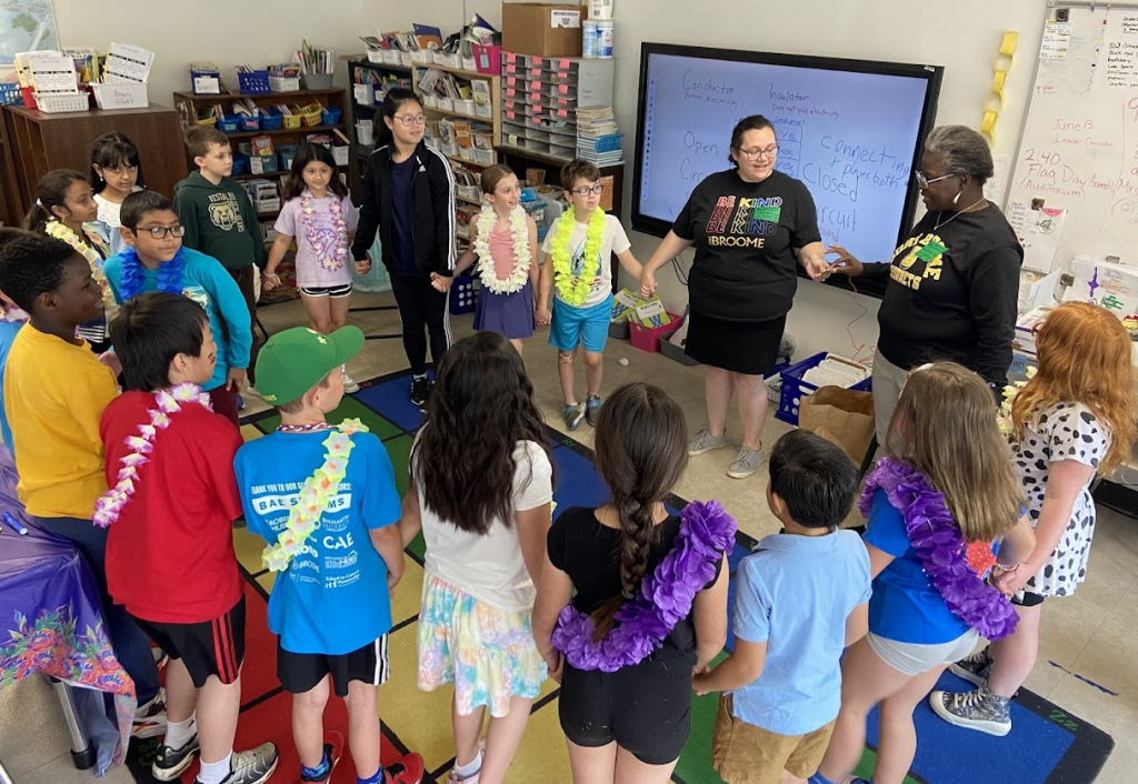 Students and adults held hands to make a continuous human circuit.