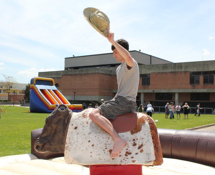 Student riding a Mechanical Bull on SUNY Broome Campus Quad