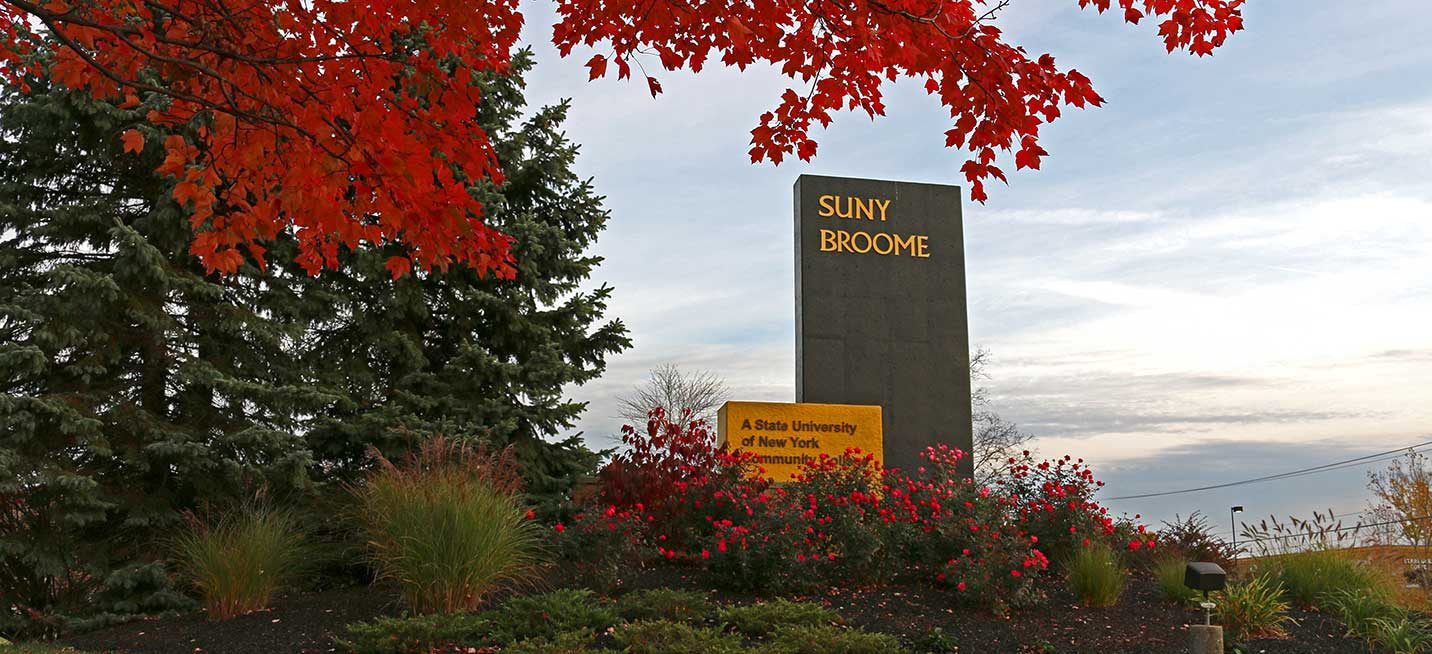 SUNY Broome monolith with autumn colors in the trees