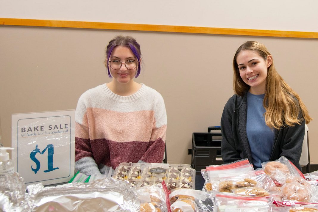 table with students and baked goods at the giving day bake sale