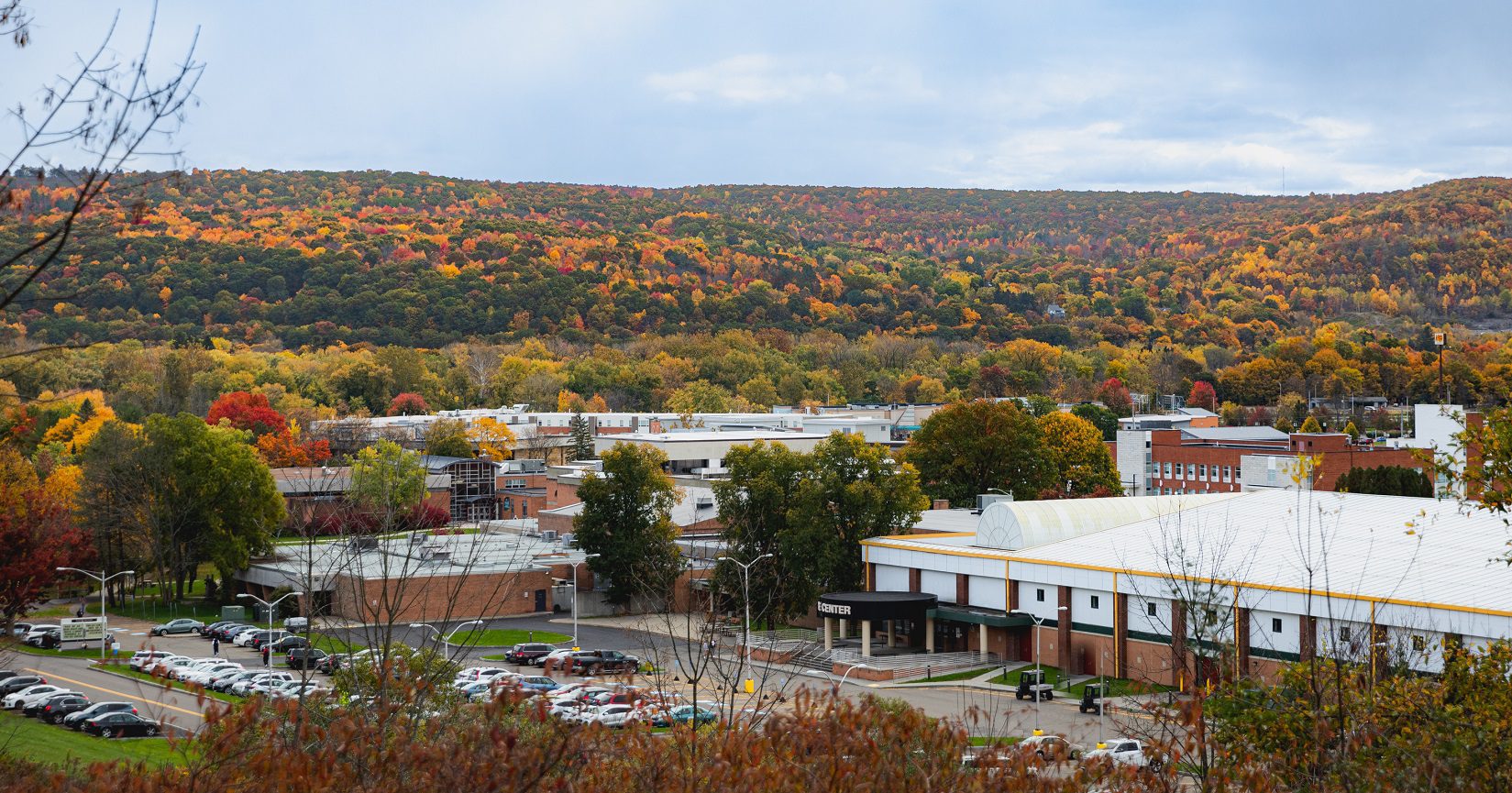 SUNY Broome Campus - Drone View - showing autumn colored trees on the hills in the background